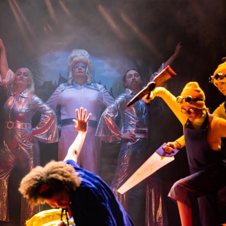 A dramatic scene as Snow White falls to the floor with the scallions behind her