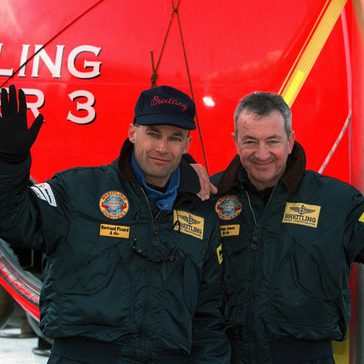 2 men standing in front of a balloon.