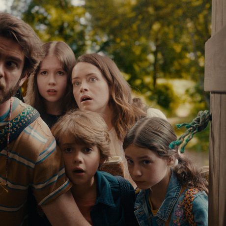 5 children close together listening to something unknown.