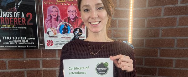 Georgia, CYP Producer, holding up her Mental Health First Aider certificate.