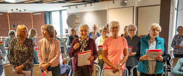 The Roses' Choir standing with music sheets in their hands