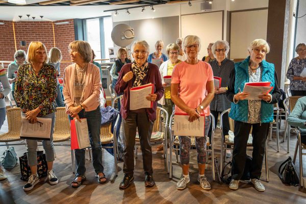 The Roses' Choir standing with music sheets in their hands