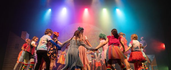 RYC children in The Wizard of Oz dancing in a circle on stage.