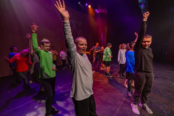 A group of children perform on a stage