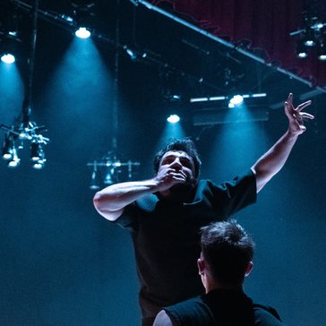 Man with his hand over his mouth on stage.