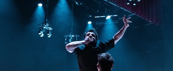 Man with his hand over his mouth on stage.