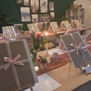 Multiple canvas with bows around them.