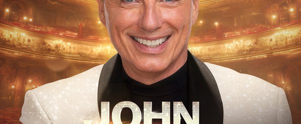 John in golden theatre with "John Barrowman: My Life in Musicals" in front of him.