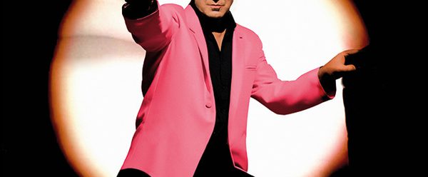 Man in the middle of a spotlight pointing.