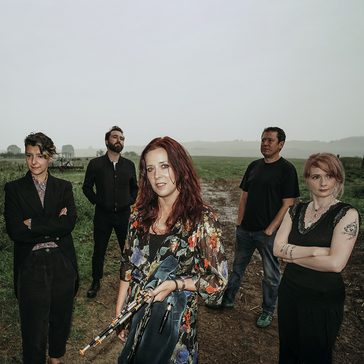 Kathryn standing with other musicians stood around her.