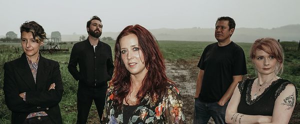 Kathryn standing with other musicians stood around her.