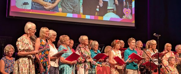 The Roses' Choir singing on stage in their 2025 Summer Concert.