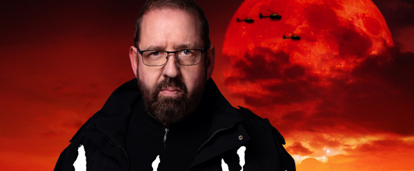 Alfie in a dark police jacket, standing against a fiery red sky with a large red moon and silhouettes of helicopters in the background. The stylized title text reads “Acopalypse Now” across the image.